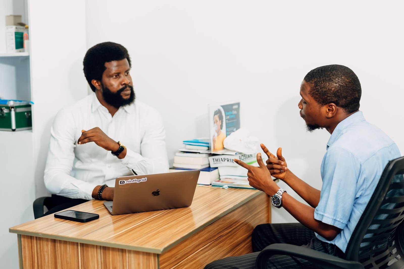 Business consultant advising a client across a desk in a Lagos office