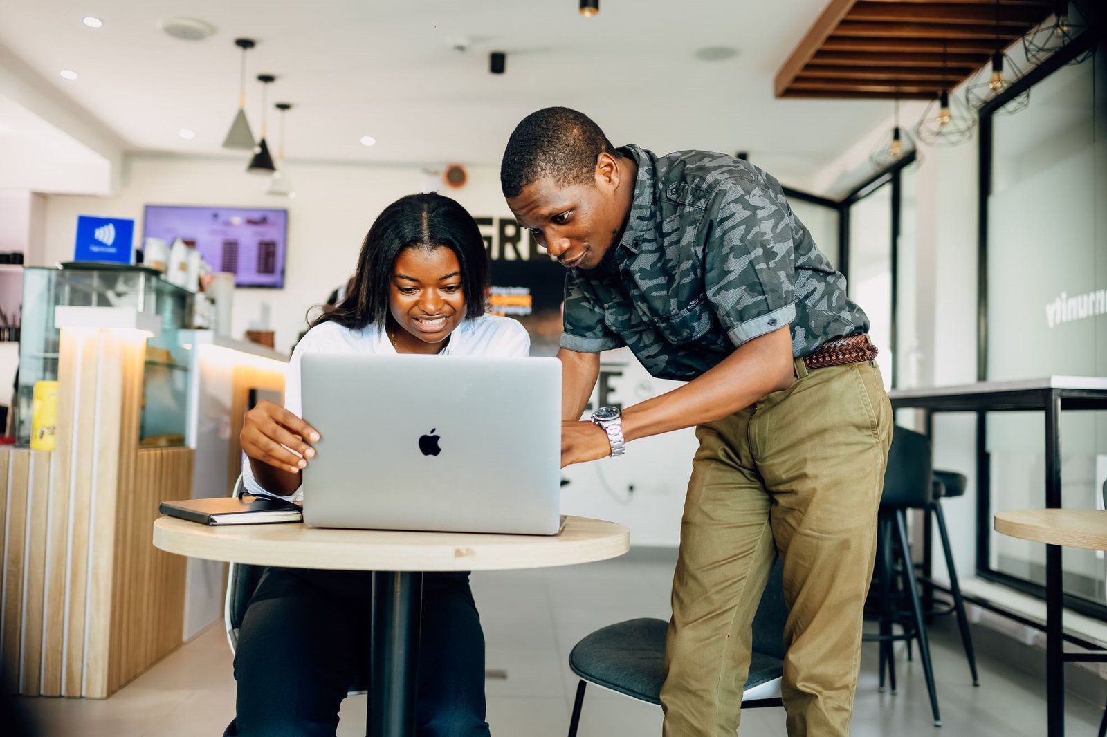 Two professionals working through a project on a laptop in a modern Lagos workspace