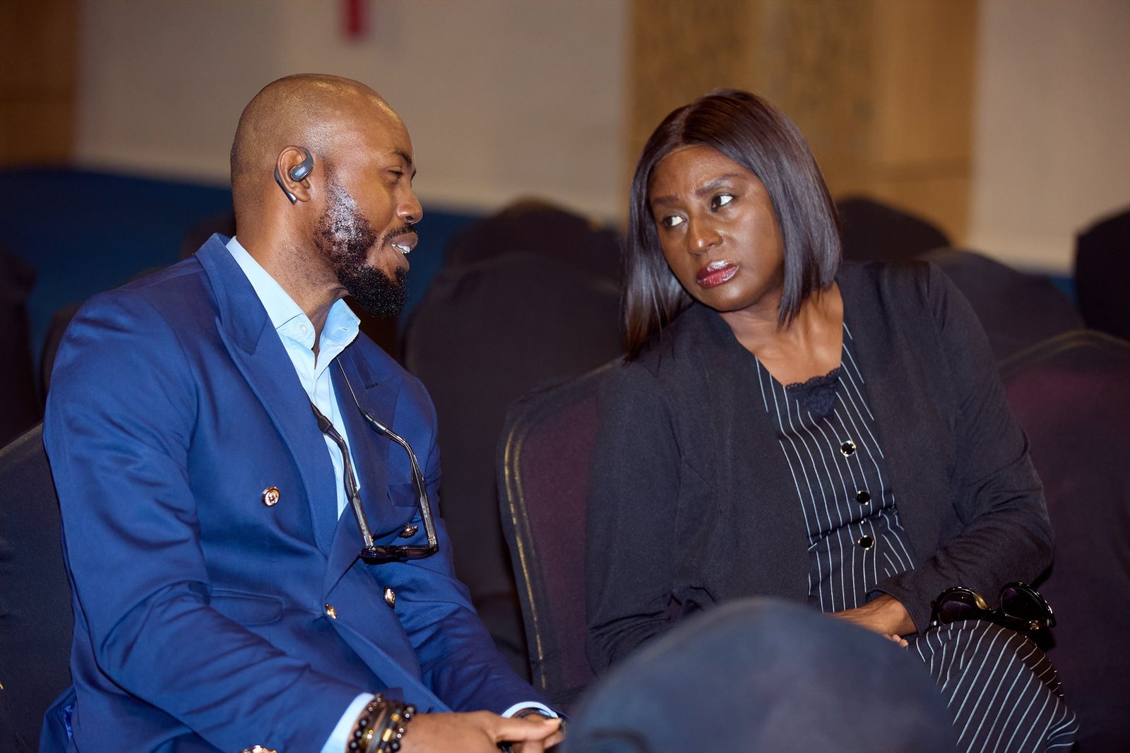 Two business leaders in close discussion during a conference session